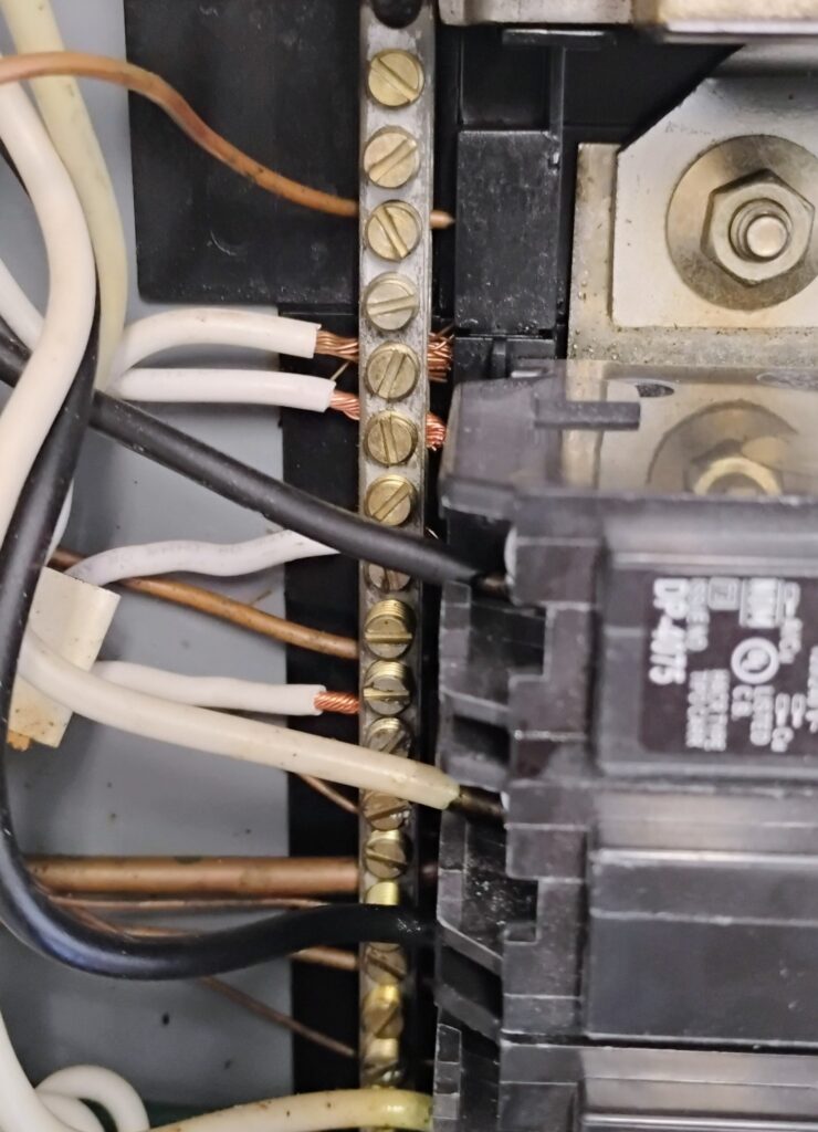 Picture of a neutral and ground bar inside an electrical panel.